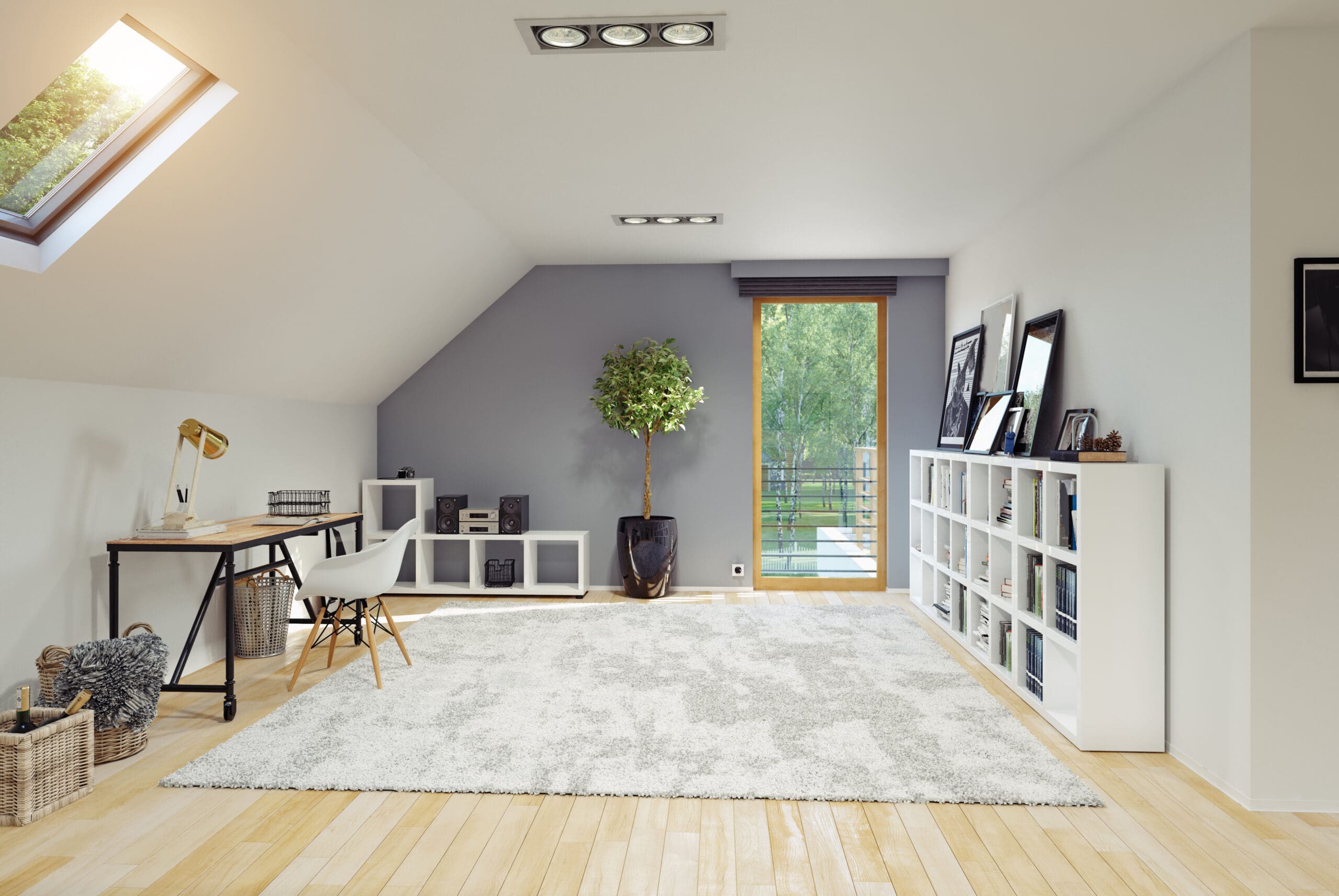 A modern, minimalist room with a slanted ceiling and skylight. It features a desk, chair, and a plant in front of a large window leading to a balcony. A white bookshelf lines one wall, and a light rug covers the wooden floor.